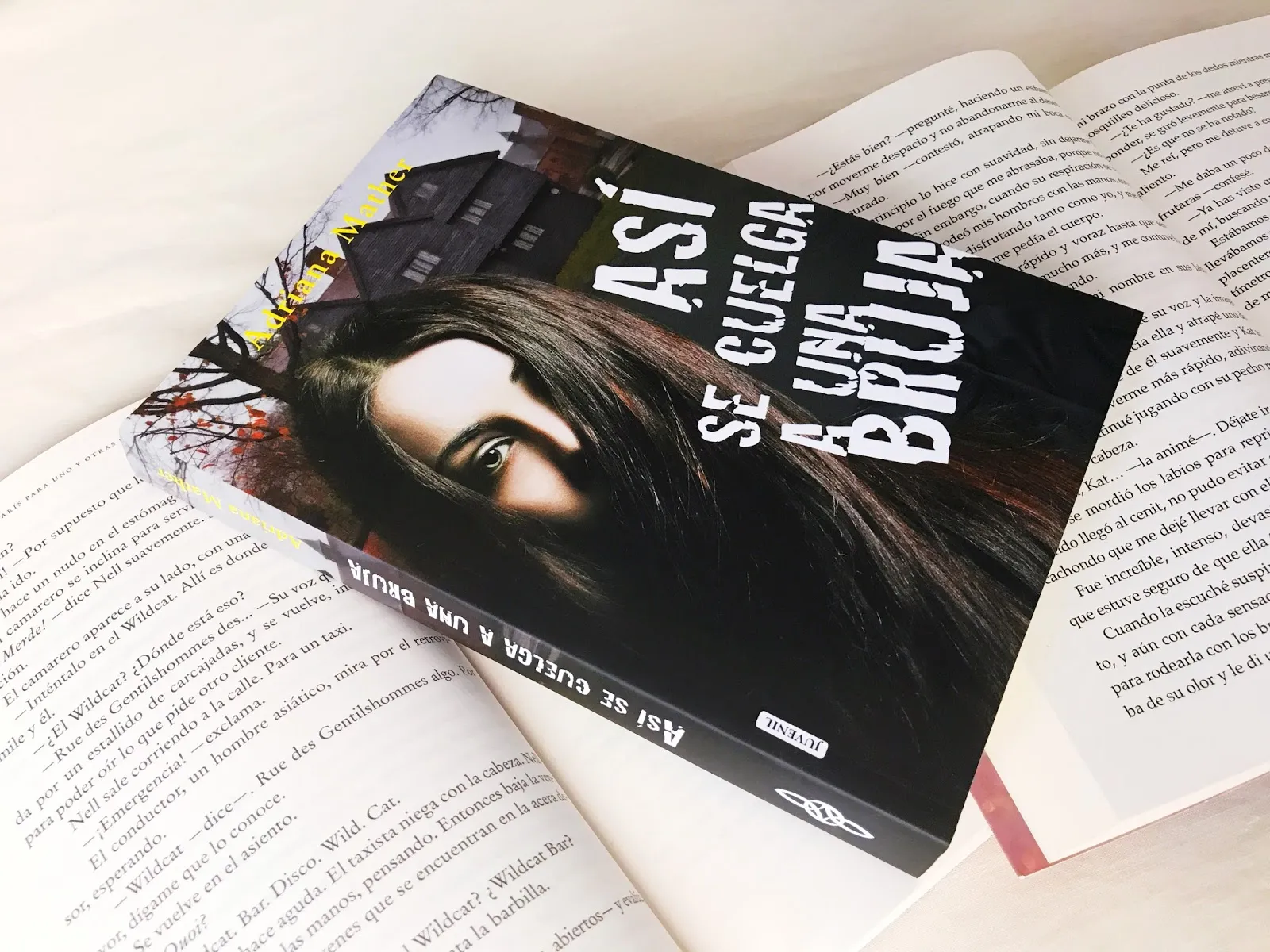 En aquesta imatge veiem la protagonista del llibre la Samantha mirat cap endavant amb una casa com fantasmagòrica al fons, el títol del llibre "Así se cuelga una bruja" i el nom de l'autora Adriana Mather